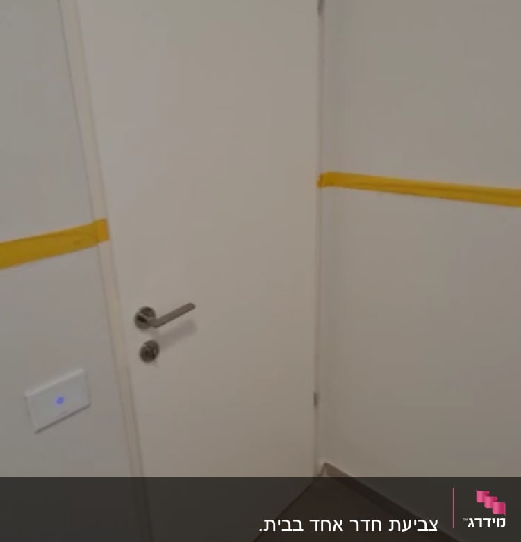 דלת לבנה עם פס צהוב על הקיר